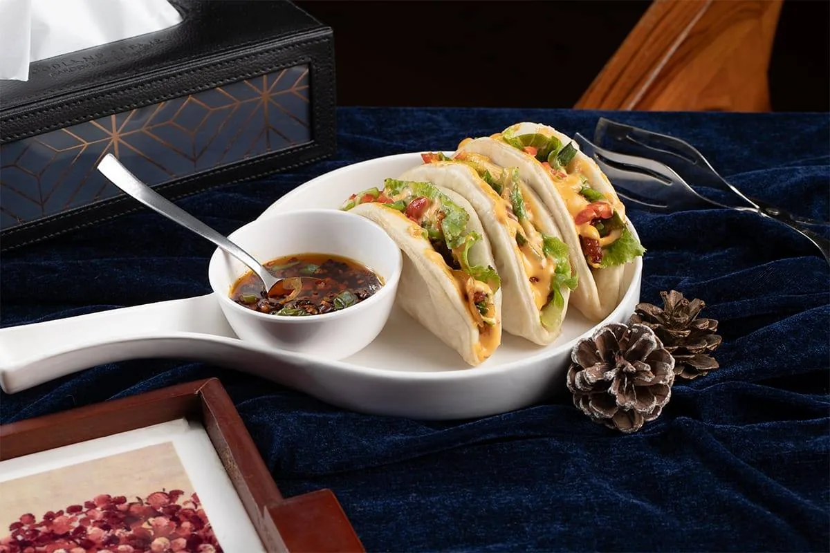 Soft tacos paired with a bowl of warm broth — comfort, plated.