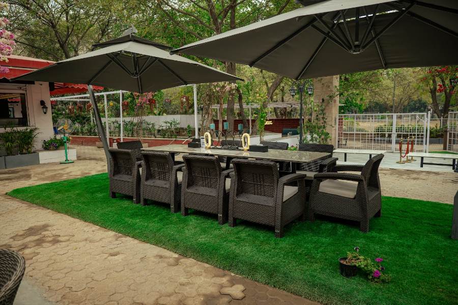 Tucked beside the lawn under a wide umbrella, a quiet spot away from the sun.