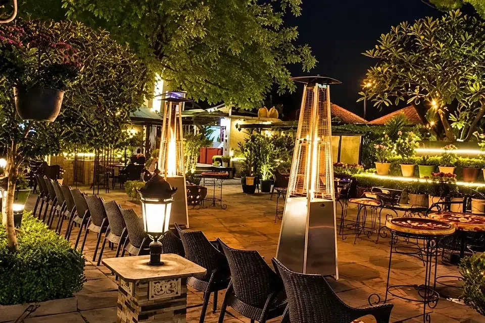 Elif towers glowing above the Woodland Affairs garden at night